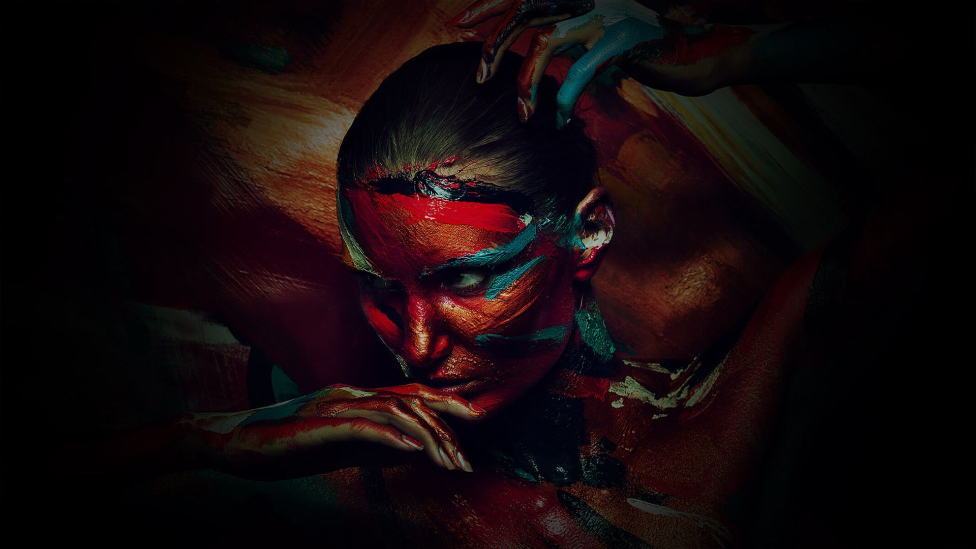 A woman with colorful paint on her face and body.