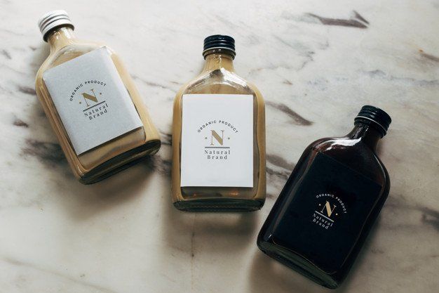 Three bottles of liquid are sitting on a table.