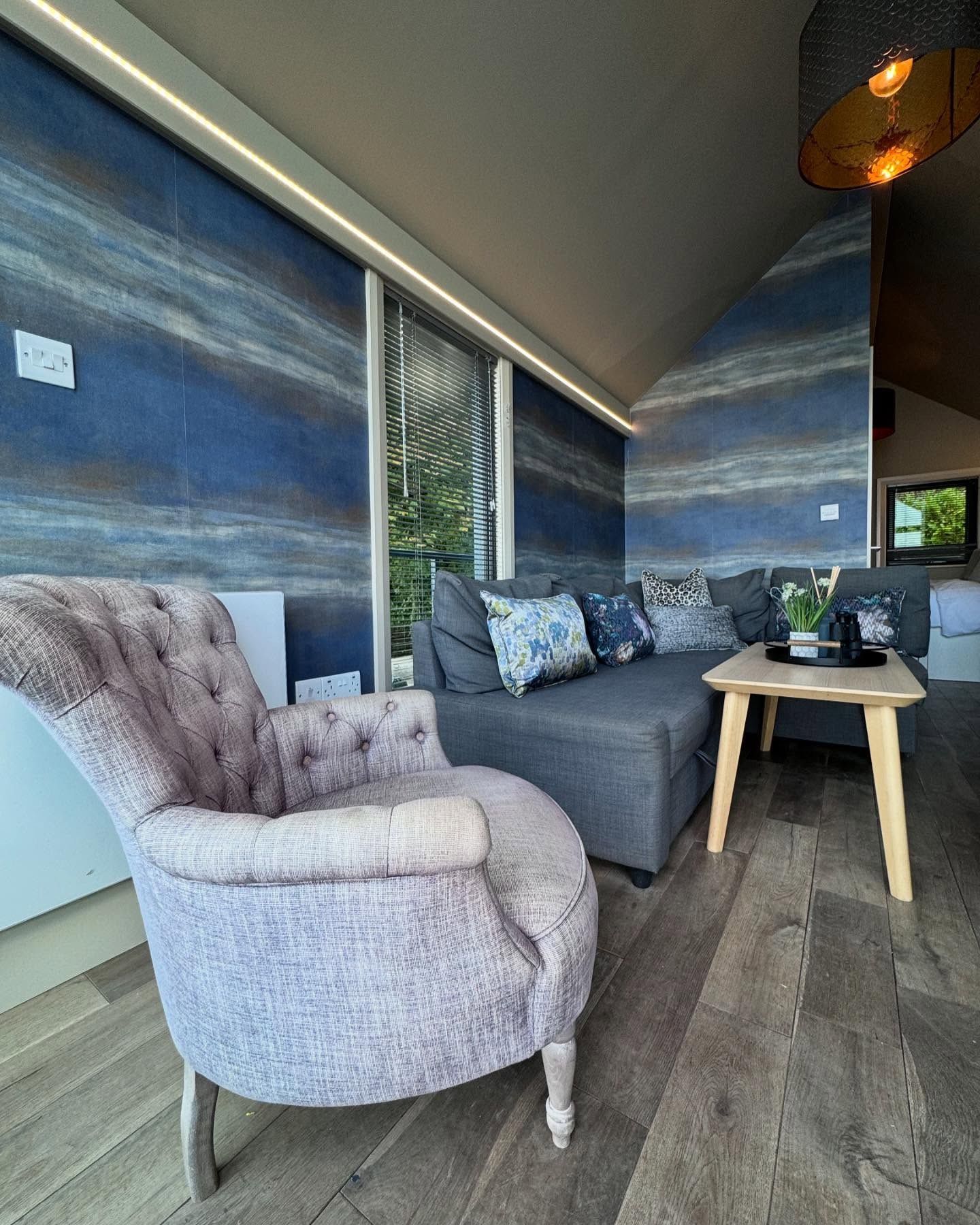 A living room with a couch , chair , table and television.