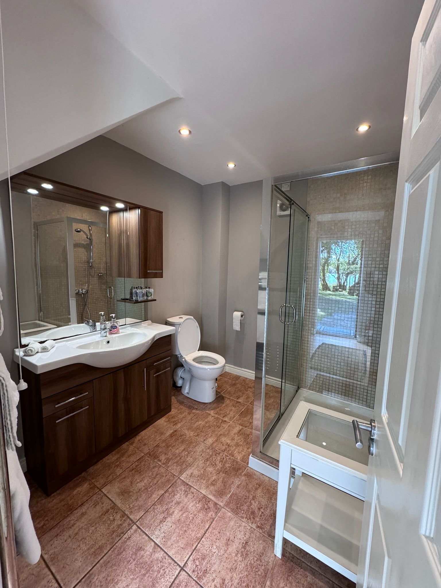 A bathroom with a toilet , sink , and shower.