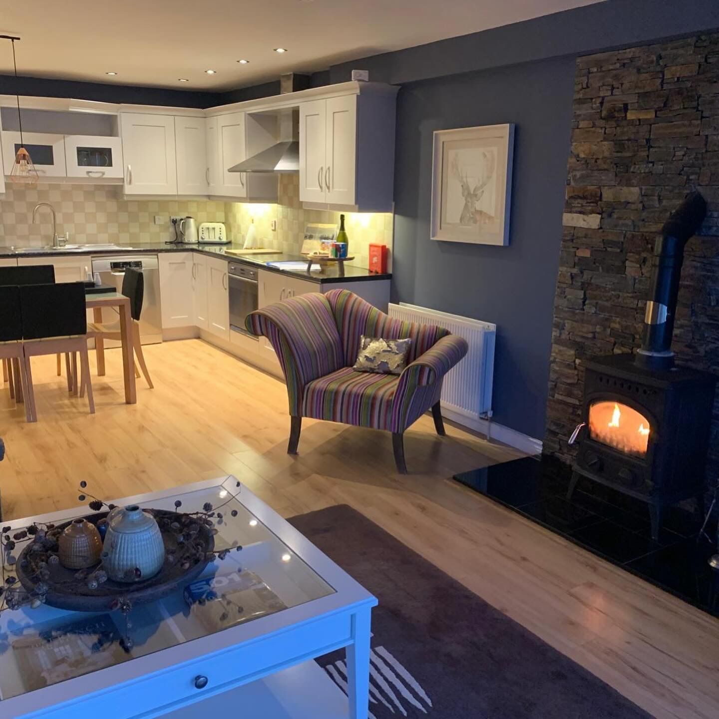A living room with a chair , table , and fireplace.