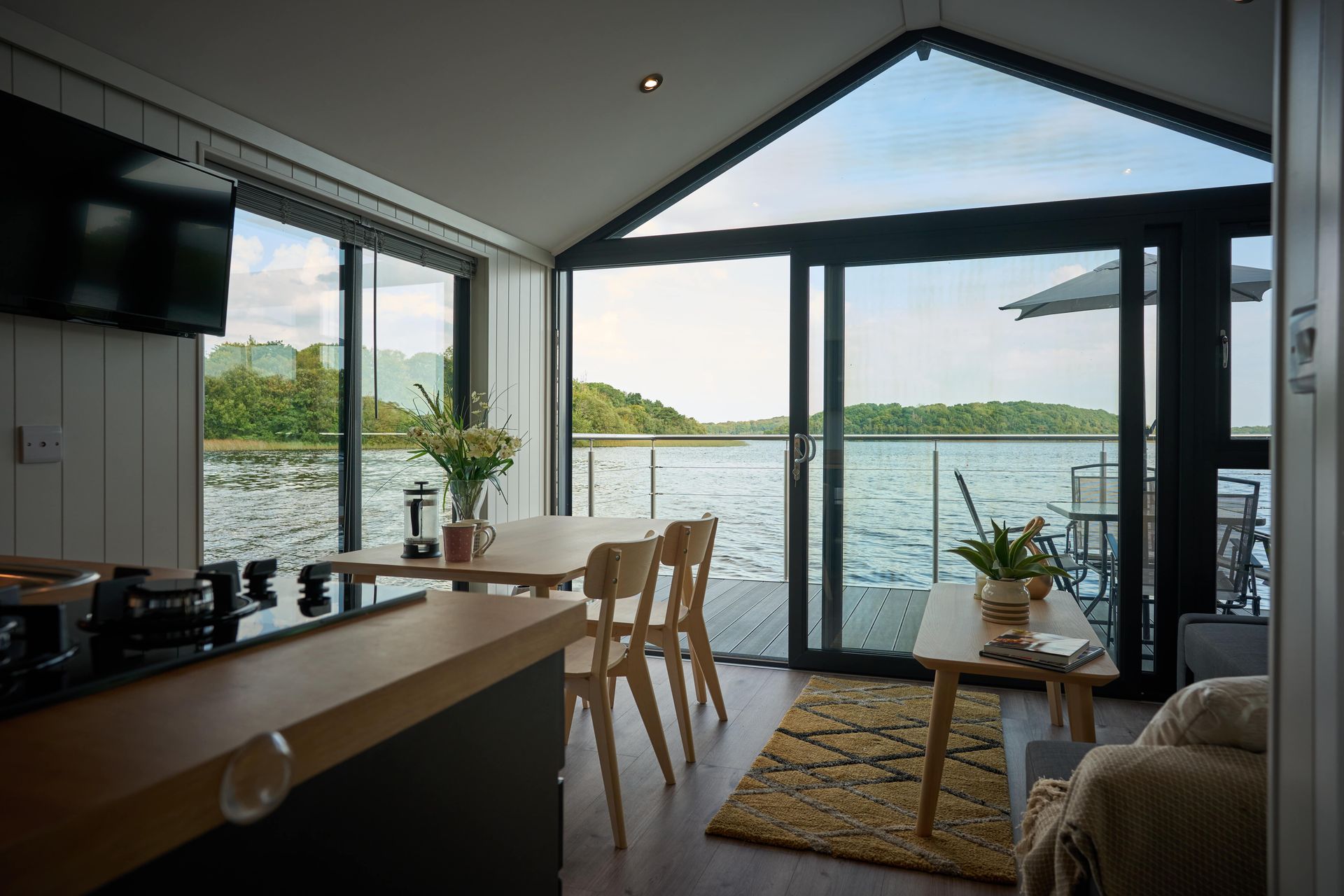 A living room with a table and chairs and a view of the water.