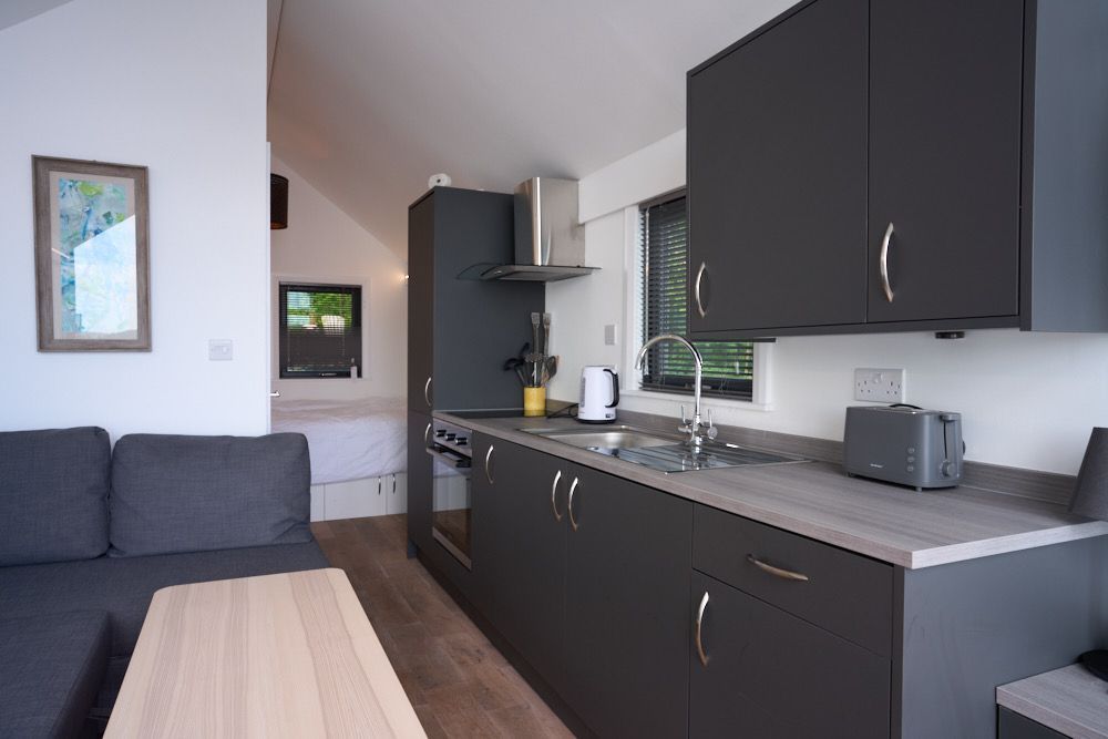 A kitchen with black cabinets and a toaster oven
