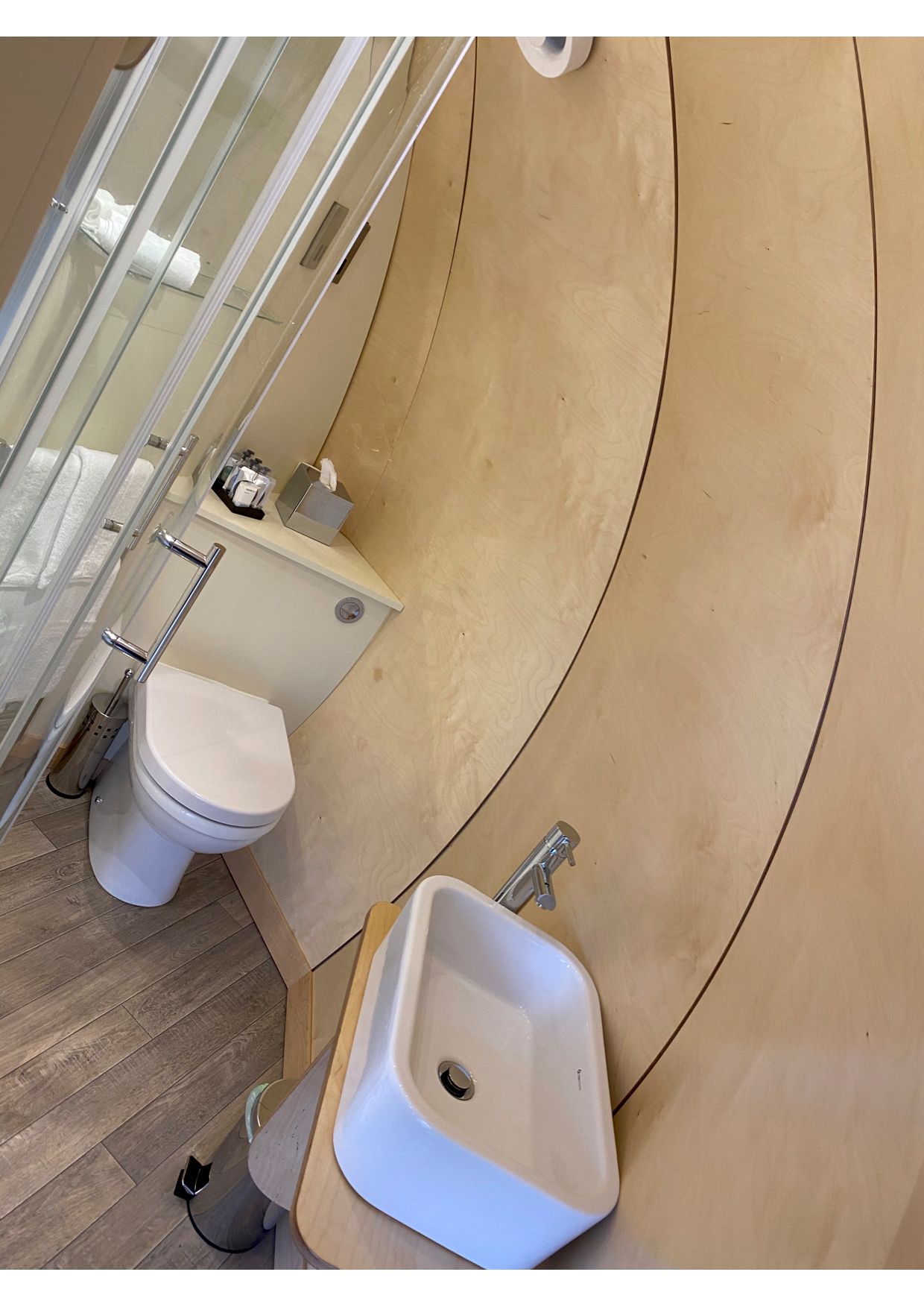 A bathroom with a toilet , sink and shower.