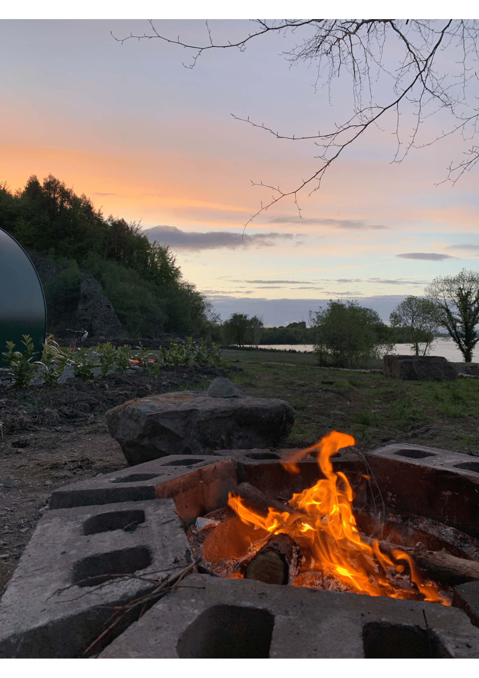A fire pit with a sunset in the background.