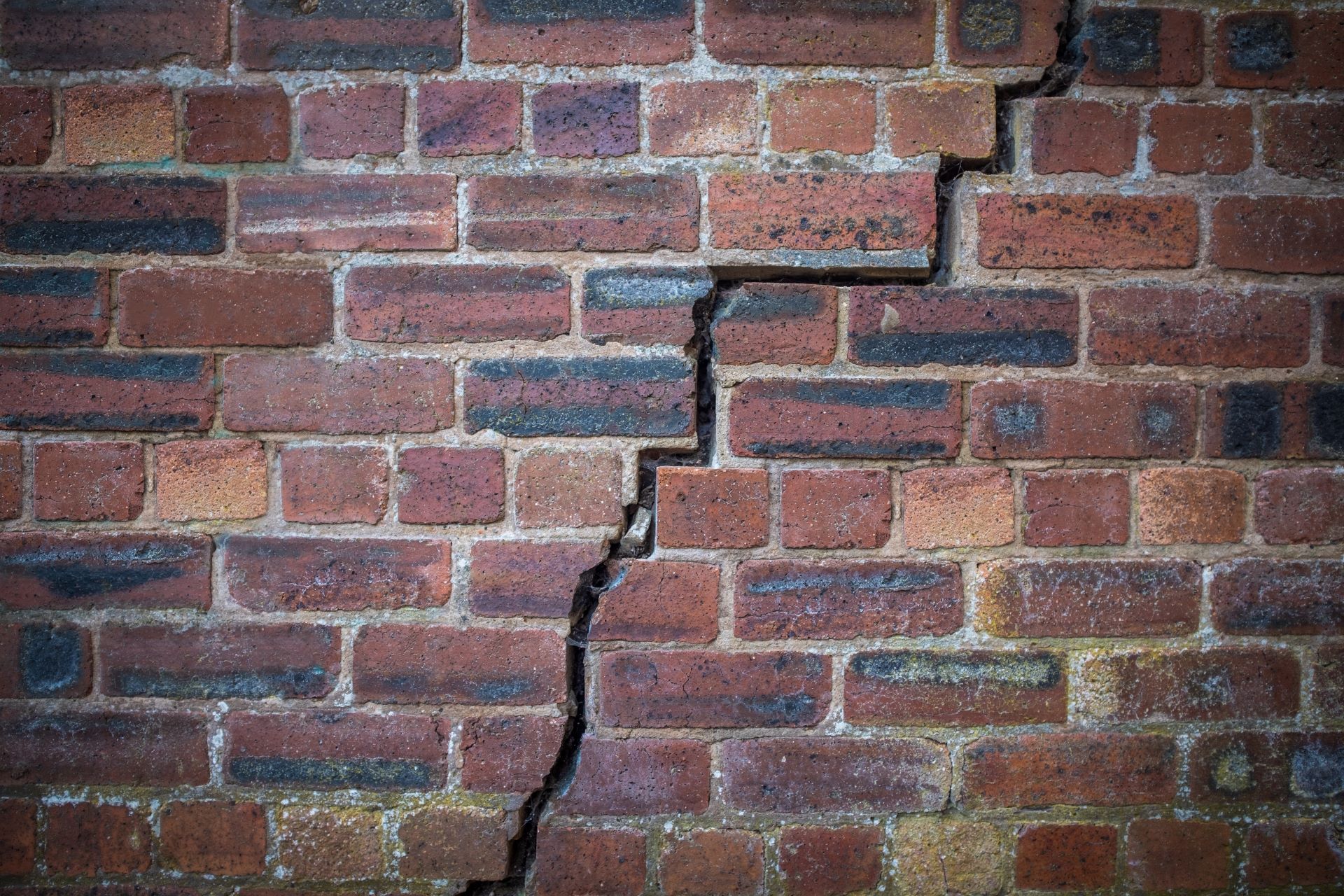 cracked brick foundation wall, leaning foundation