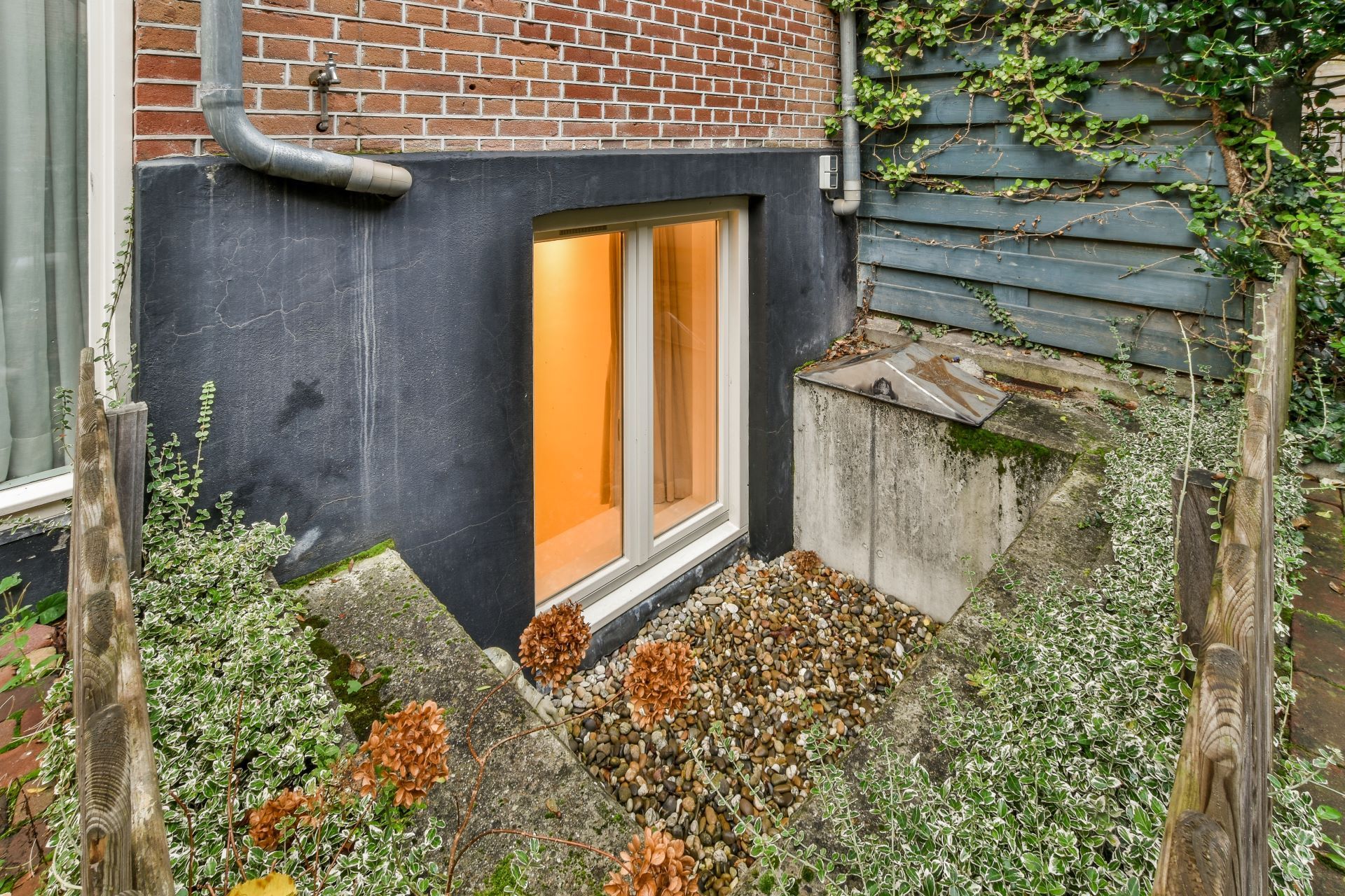 A window in the basement of a brick house