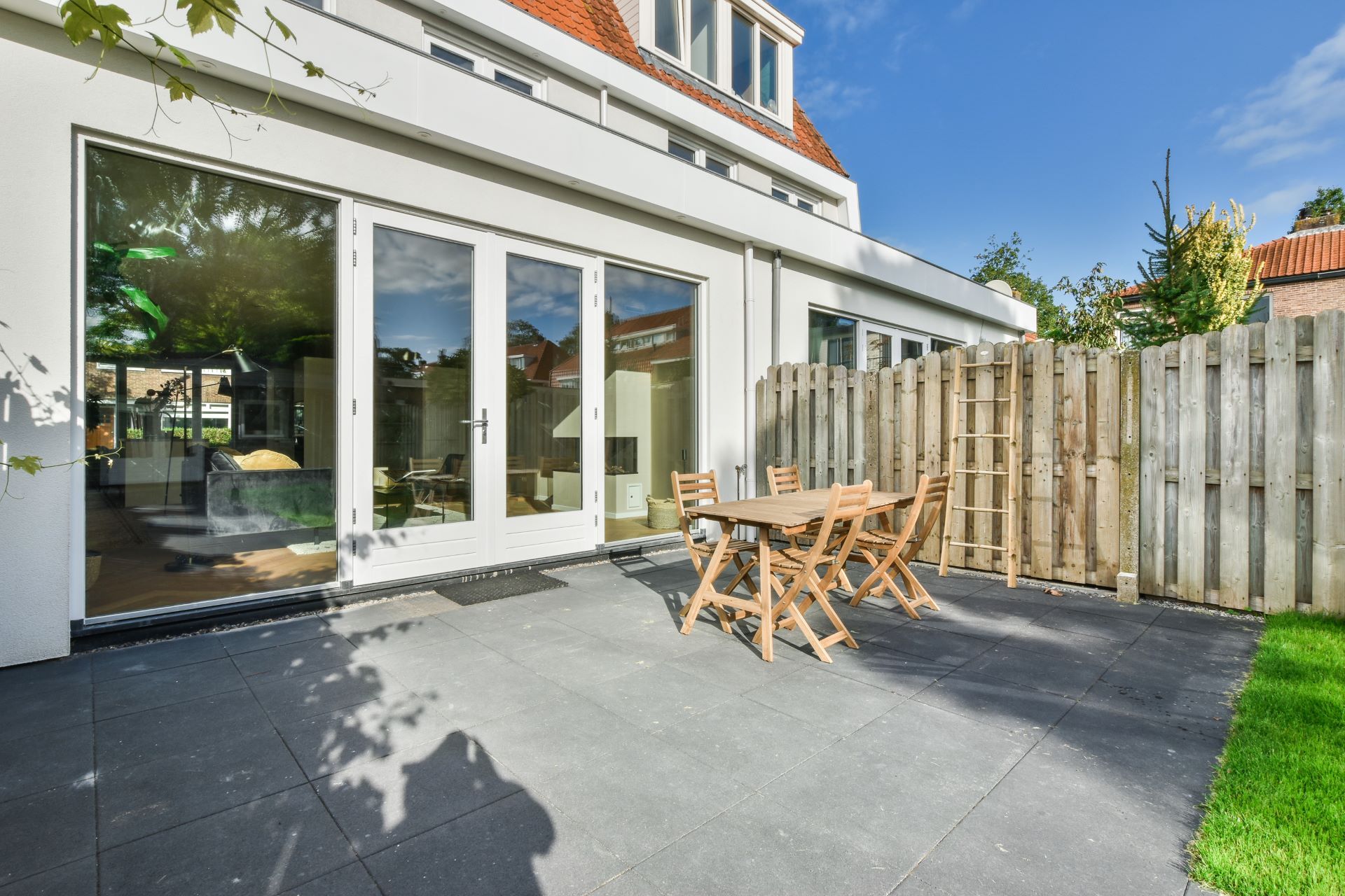 A patio with a table and chairs in front of a house.