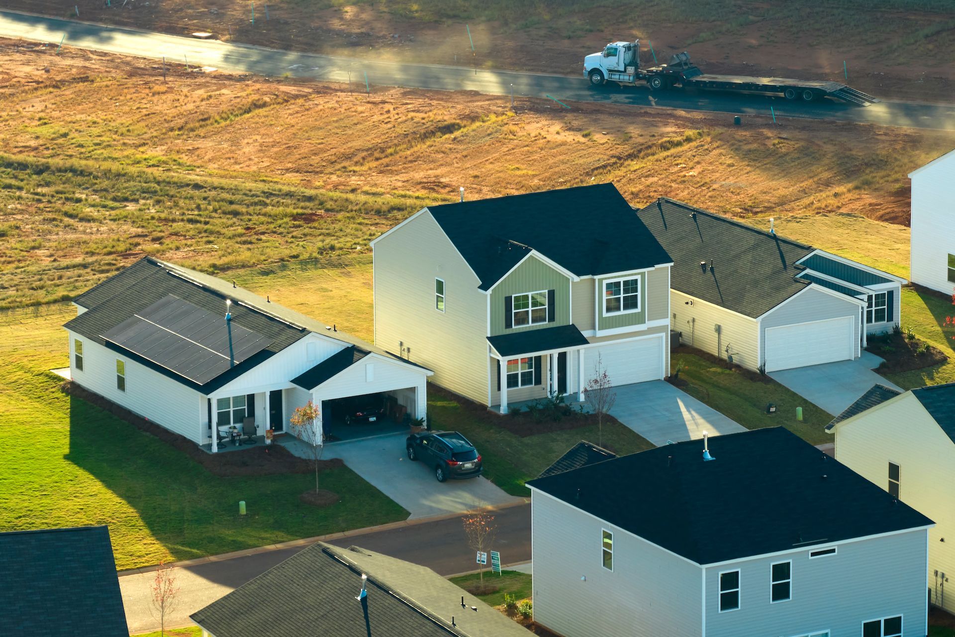 An aerial view of a residential neighborhood with houses and a truck in the background.