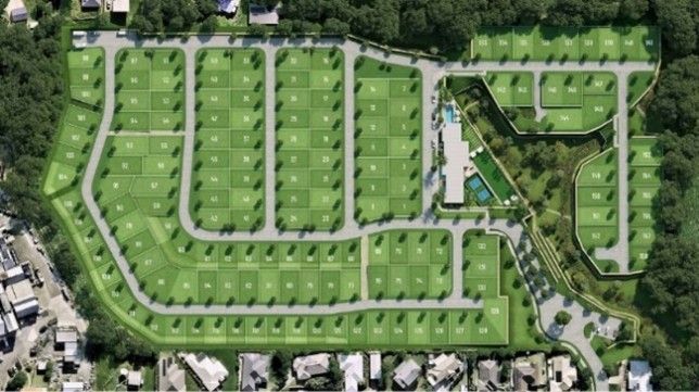 Aerial view of a planned neighborhood with green lawns, winding streets, and rows of houses around a central pool