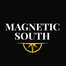 White “MAGNETIC SOUTH” text on black background with gold compass-like emblem underneath