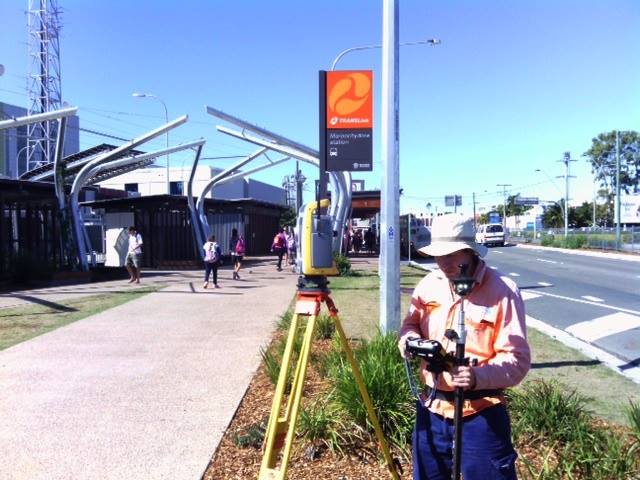 man surveying on the side of a city road