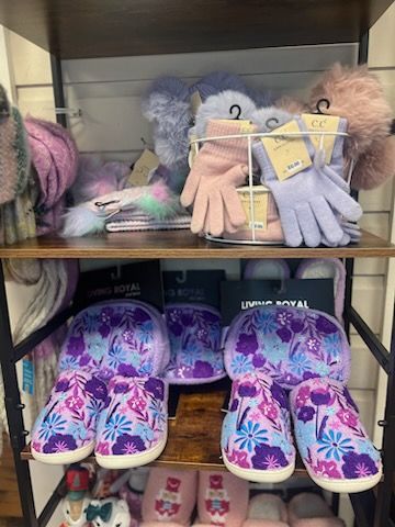 A shelf filled with slippers , gloves , and hats.