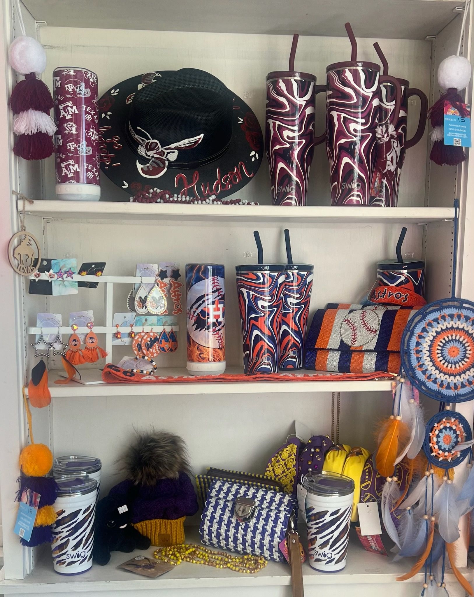 A shelf filled with a variety of tumblers , hats , handbags , and other items.