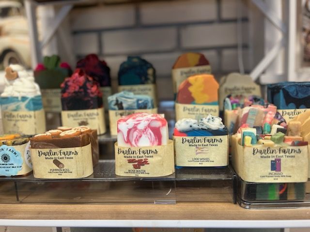 A variety of soaps are displayed on a shelf in a store.