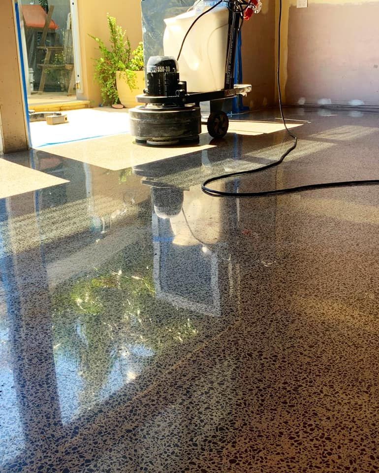 Polished concrete floor reflecting sunlight, with a floor grinder in the background. — Showcase Concrete & Polishing in Moore Park Beach, QLD
