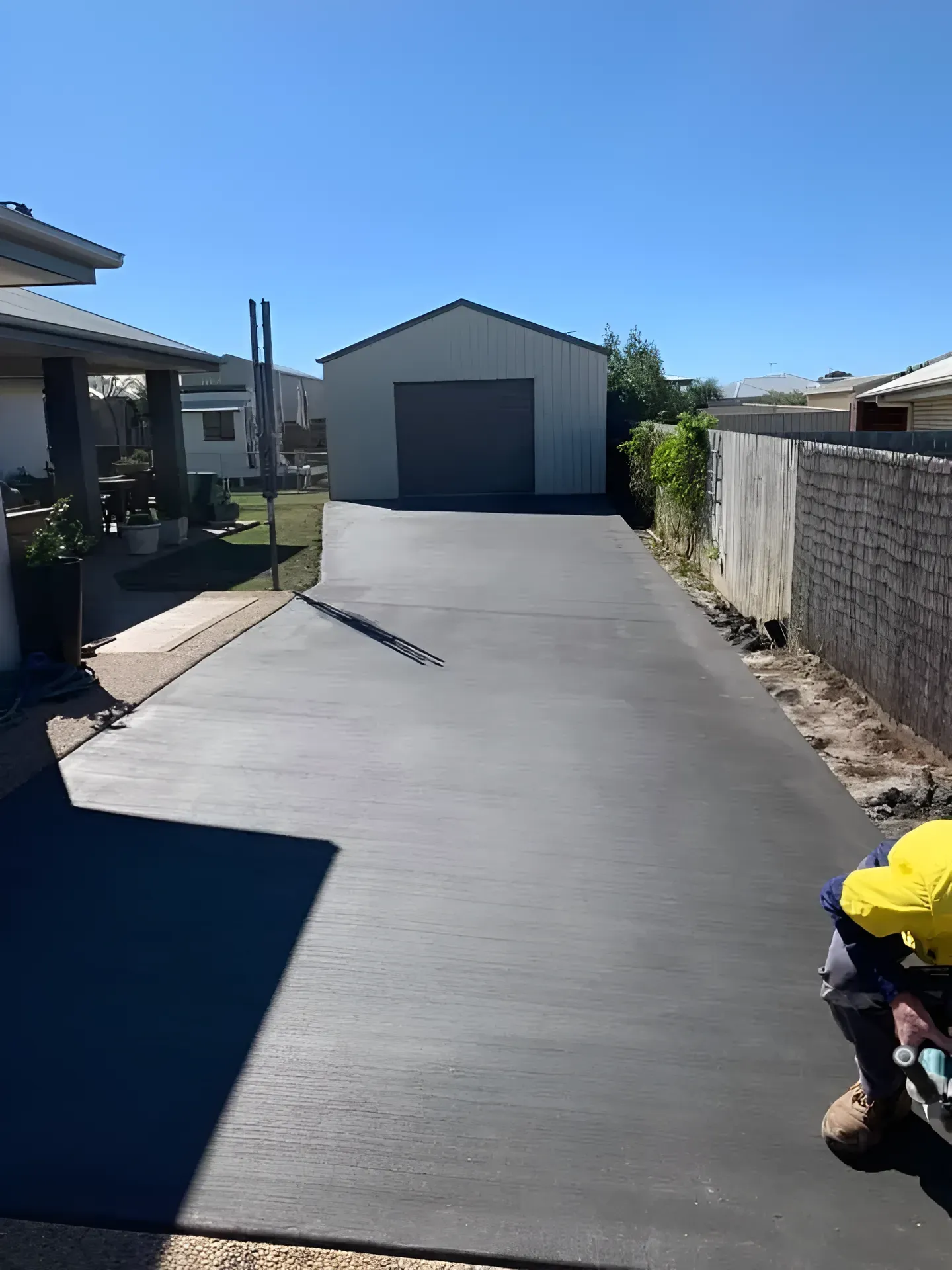 Newly Paved Driveway Leading to a Grey Shed — Showcase Concrete & Polishing in Moore Park Beach, QLD