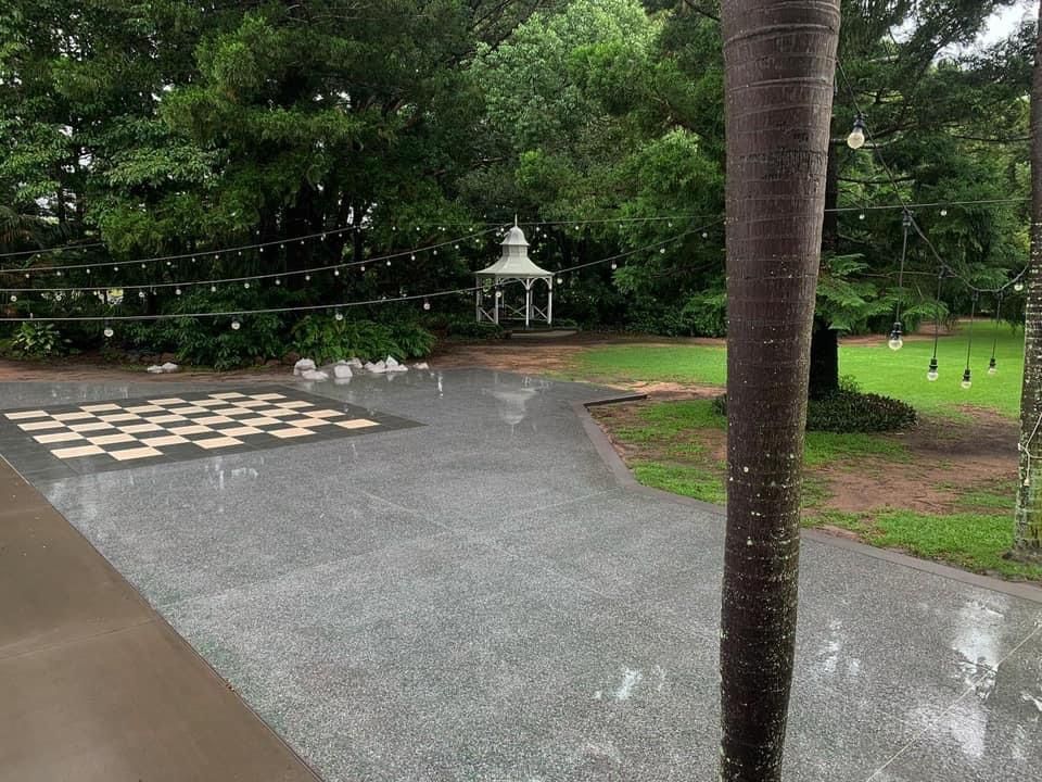 Rainy outdoor area with checkerboard, gazebo, and string lights Showcase Concrete & Polishing in Moore Park Beach, QLD