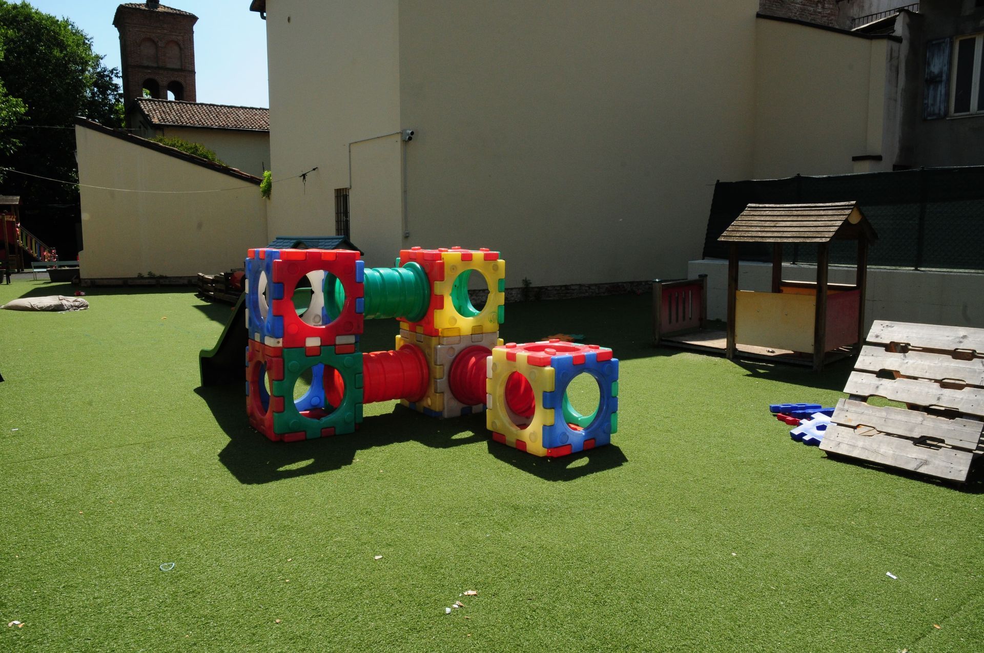 Un parco giochi colorato con una casa di legno sullo sfondo