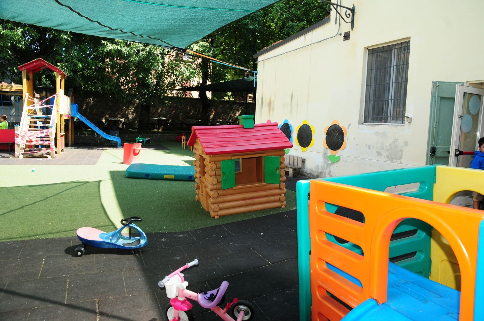 Un parco giochi per bambini con una casa di legno e uno scivolo.
