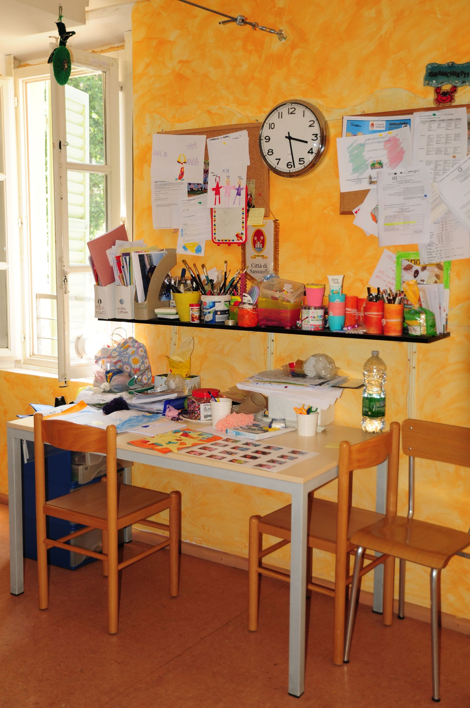 Una stanza con un tavolo e delle sedie e un orologio sul muro