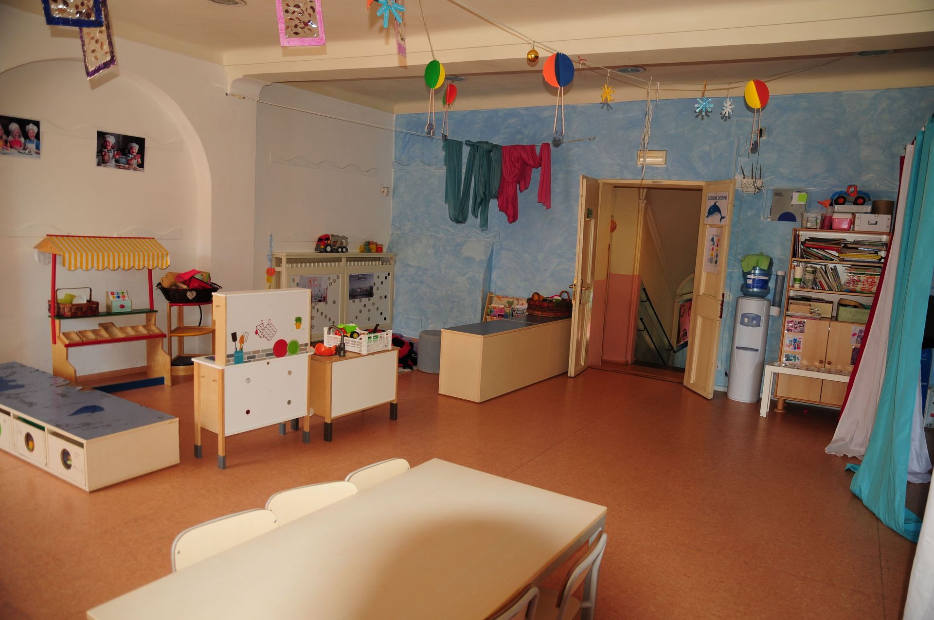 Una grande stanza con un tavolo e delle sedie