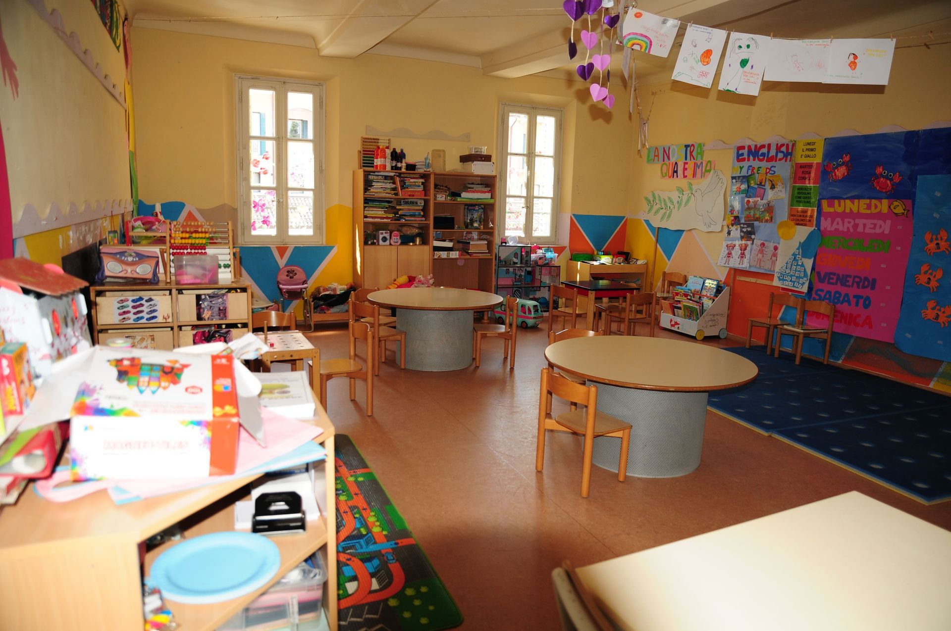 Un'aula con tavoli e sedie e un cartello che dice inglese