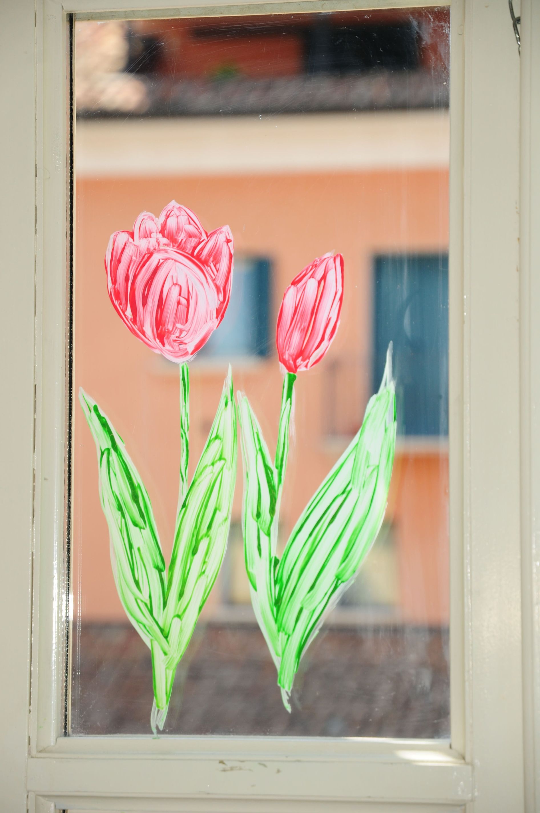 Disegno di un bambino di due tulipani su una finestra.