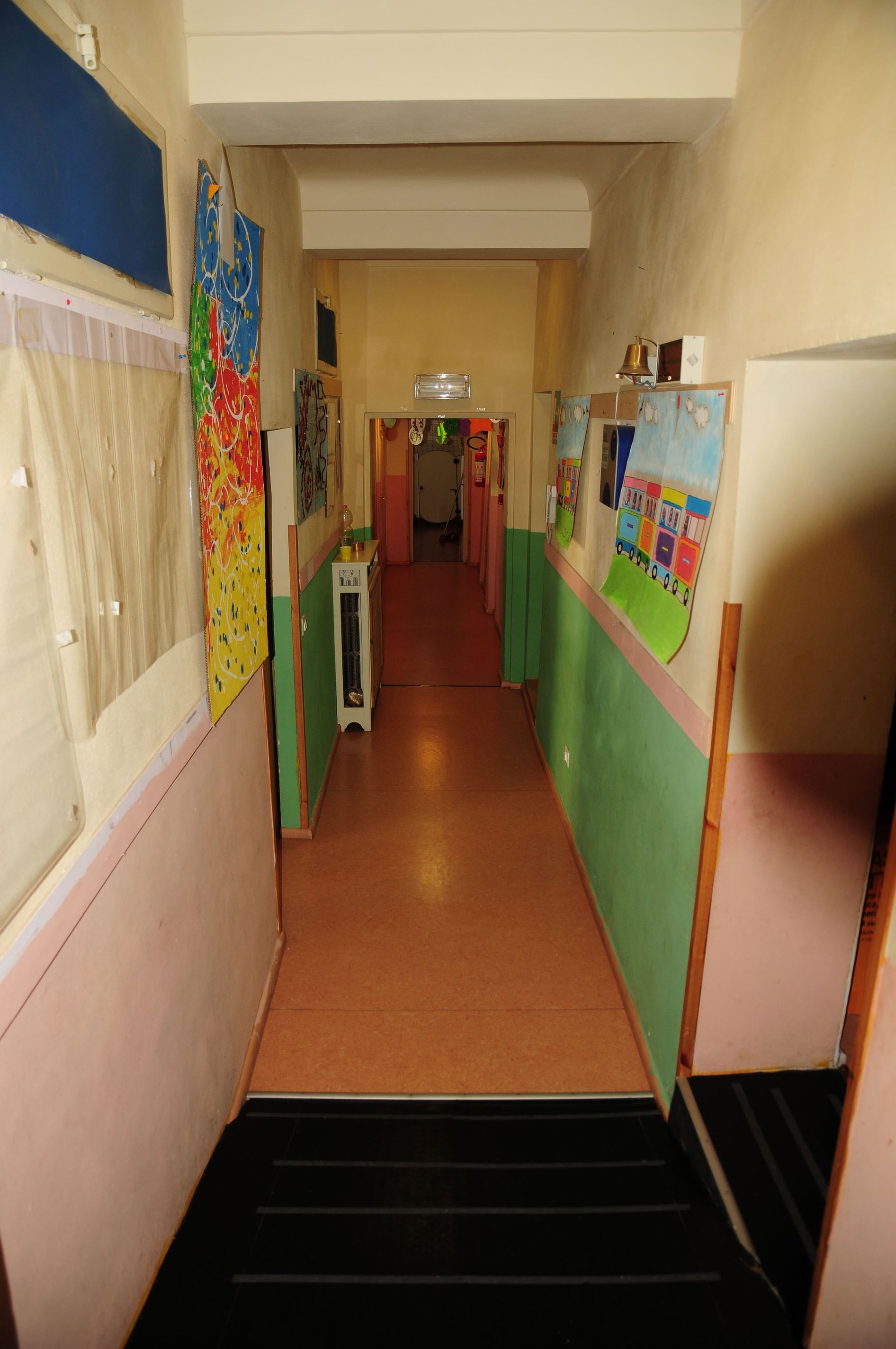 Un lungo corridoio con pareti rosa e verdi