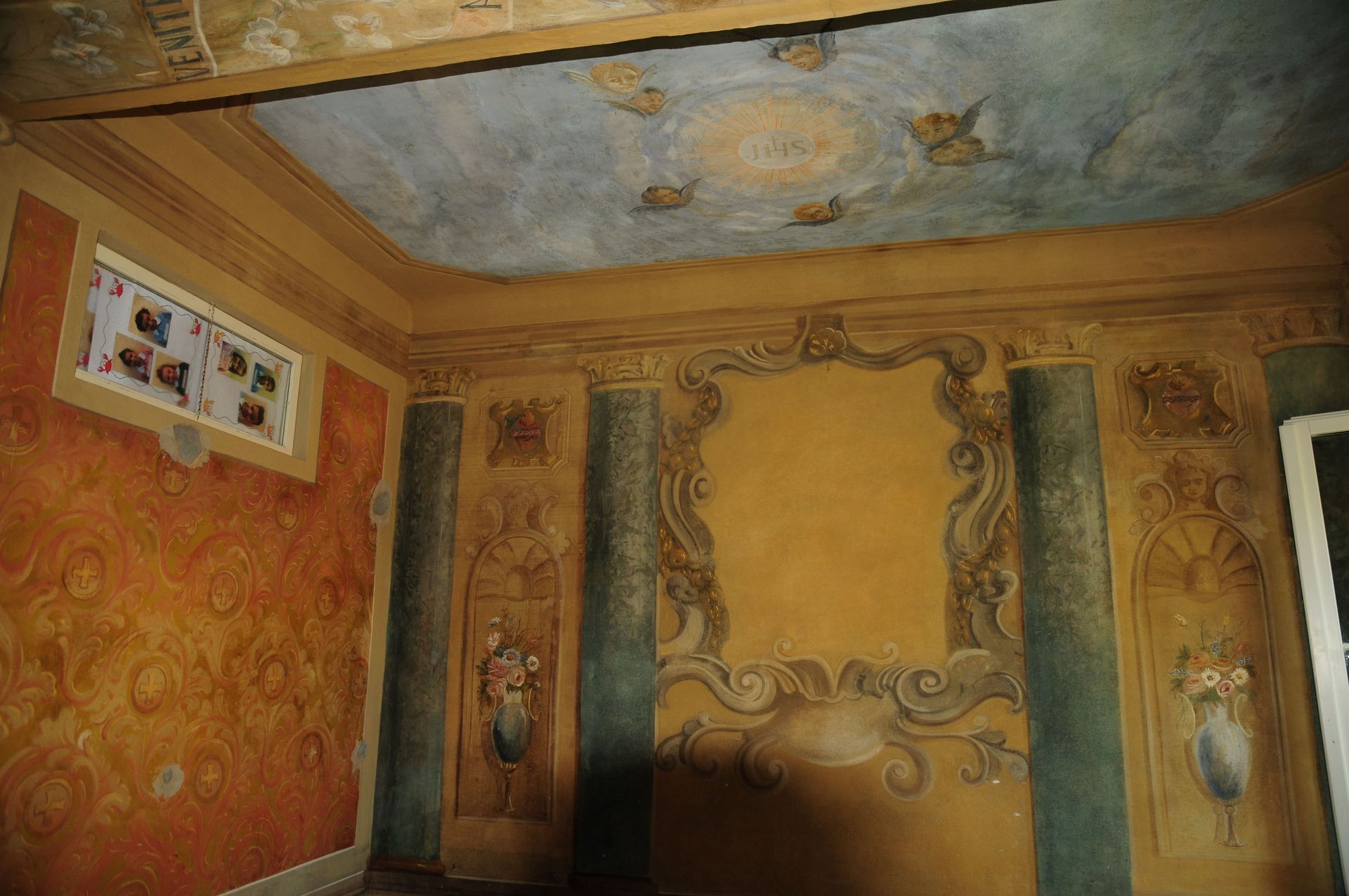 Una stanza con colonne e un dipinto sul soffitto