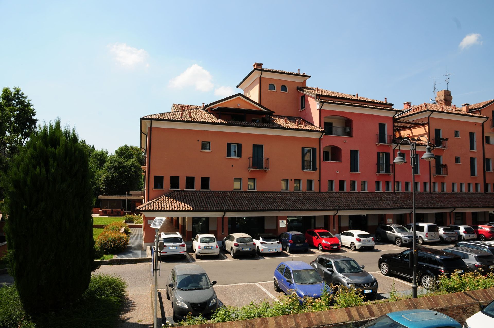 Un edificio con molte auto parcheggiate di fronte