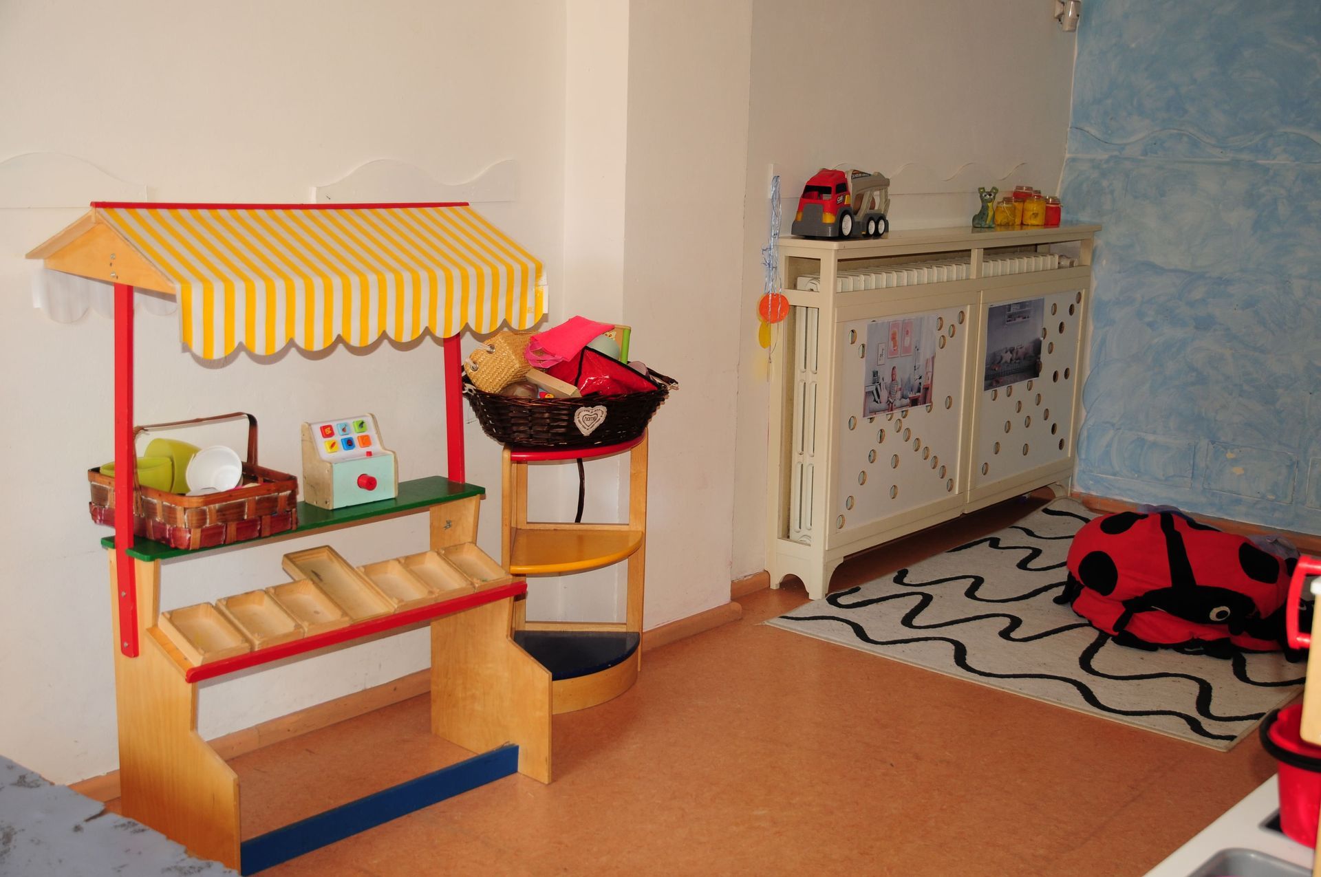 Una sala giochi per bambini con una coccinella sul pavimento