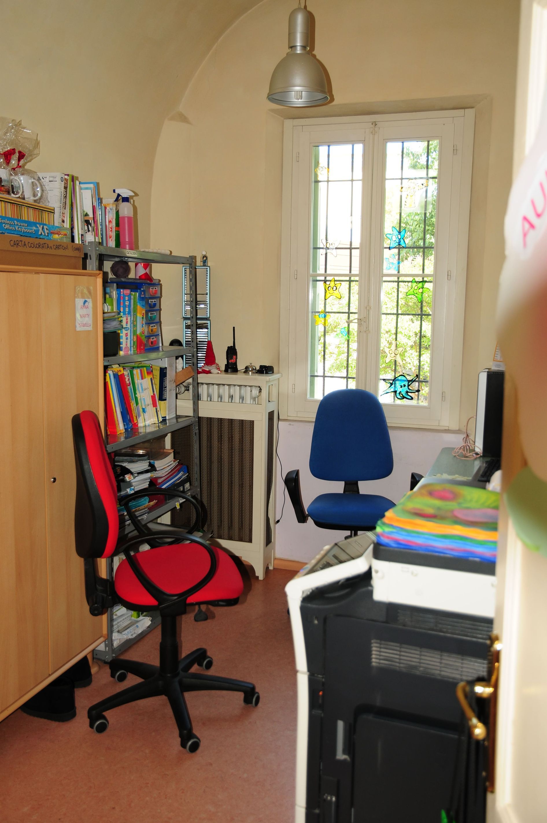 Una stanza con una sedia rossa e una sedia blu