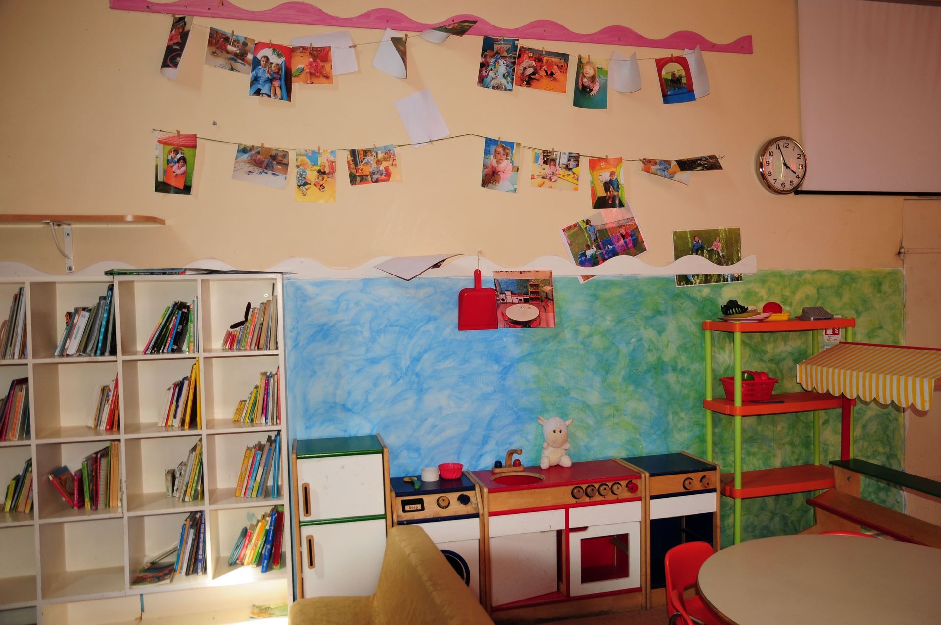 Una stanza con uno scaffale pieno di libri e un orologio sul muro