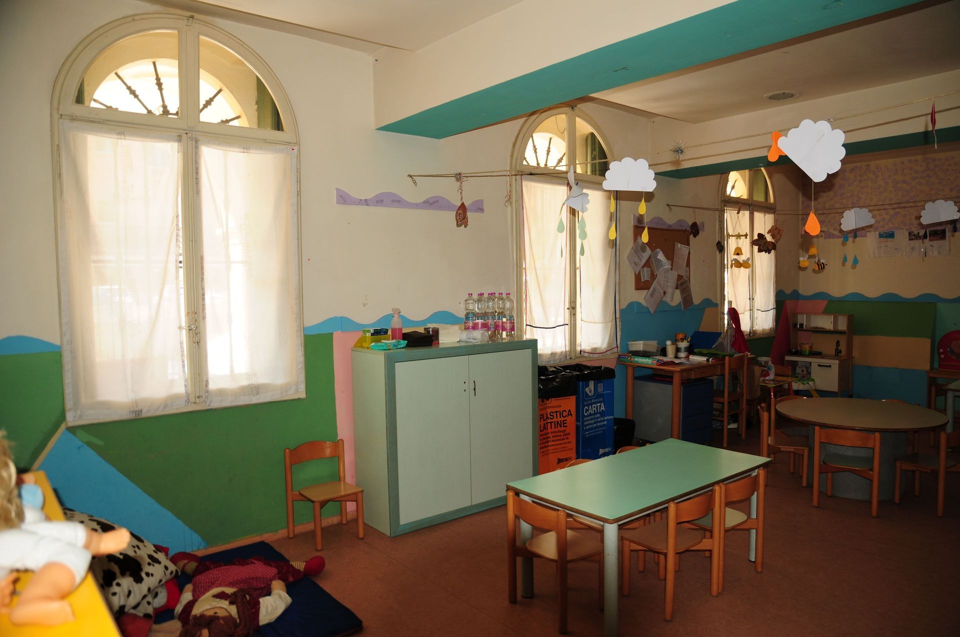 Un'aula con tavoli e sedie e decorazioni appese al soffitto