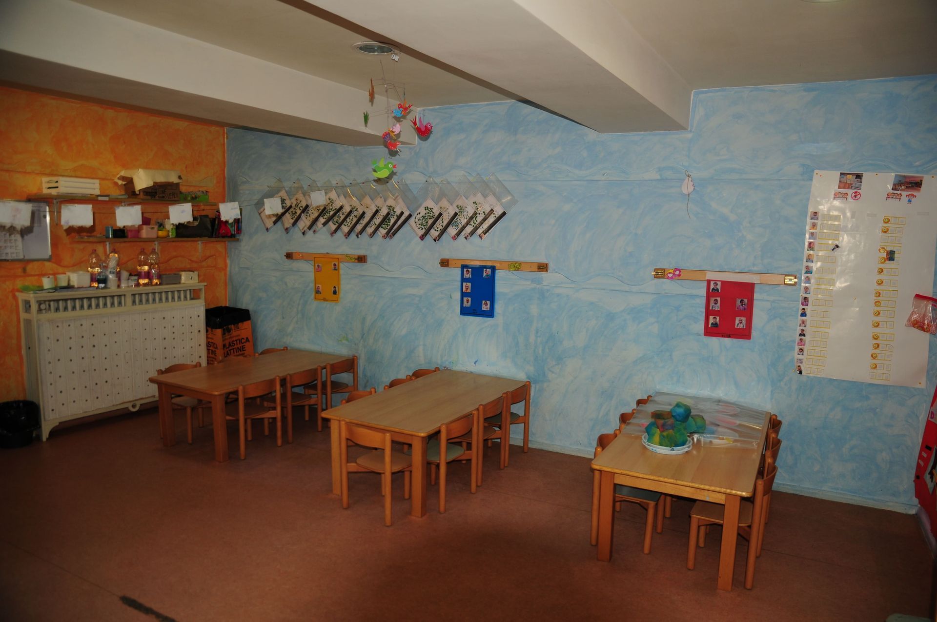 Una stanza con tavoli e sedie e una parete blu