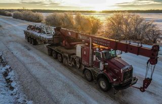 A picture of a red 45 tonne picker truck in a yard in Grande Prairie.