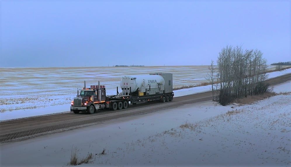 A picture of a winch tractor trucking oilfield equipment.