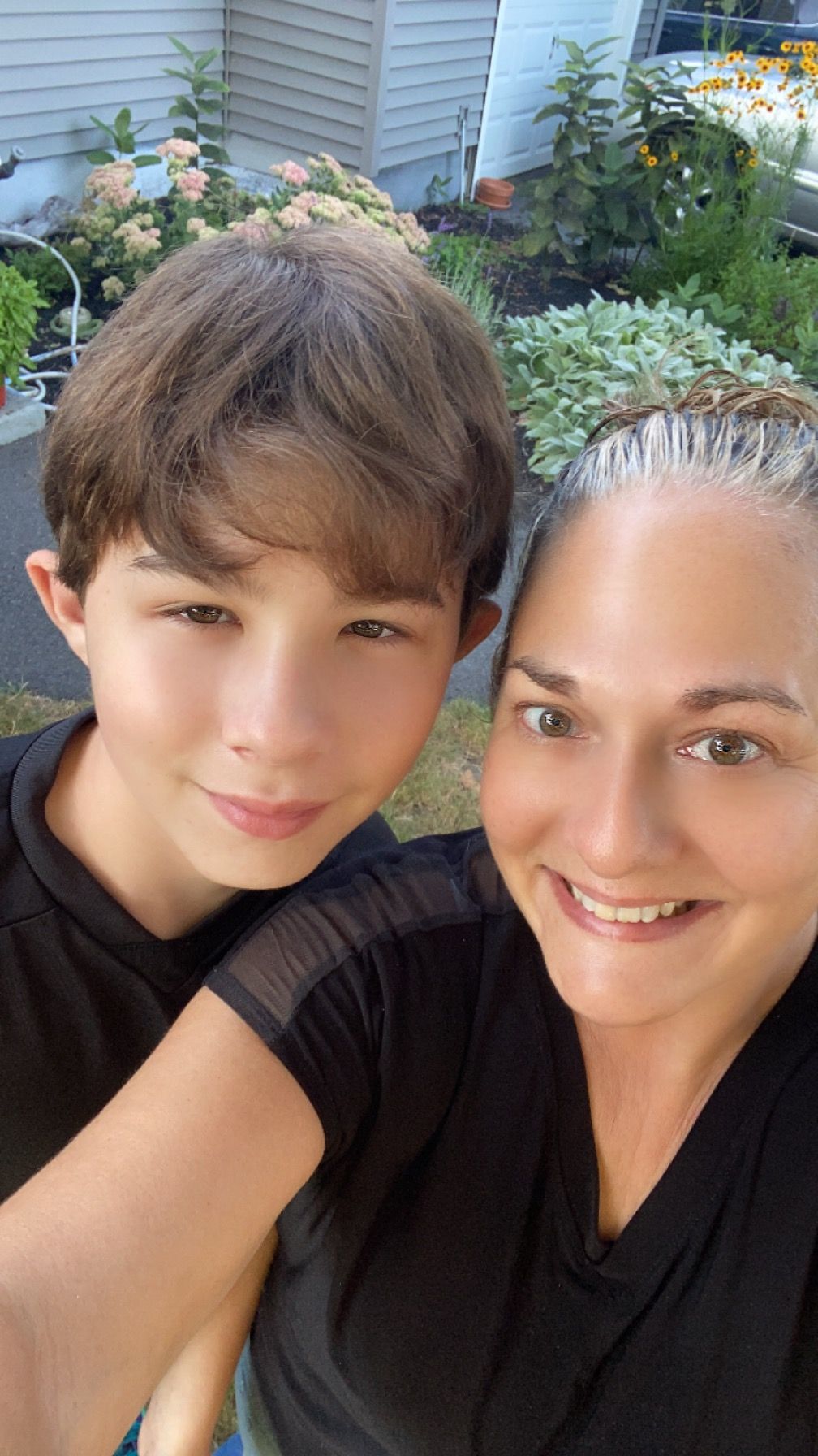 A woman and a boy are posing for a picture together.