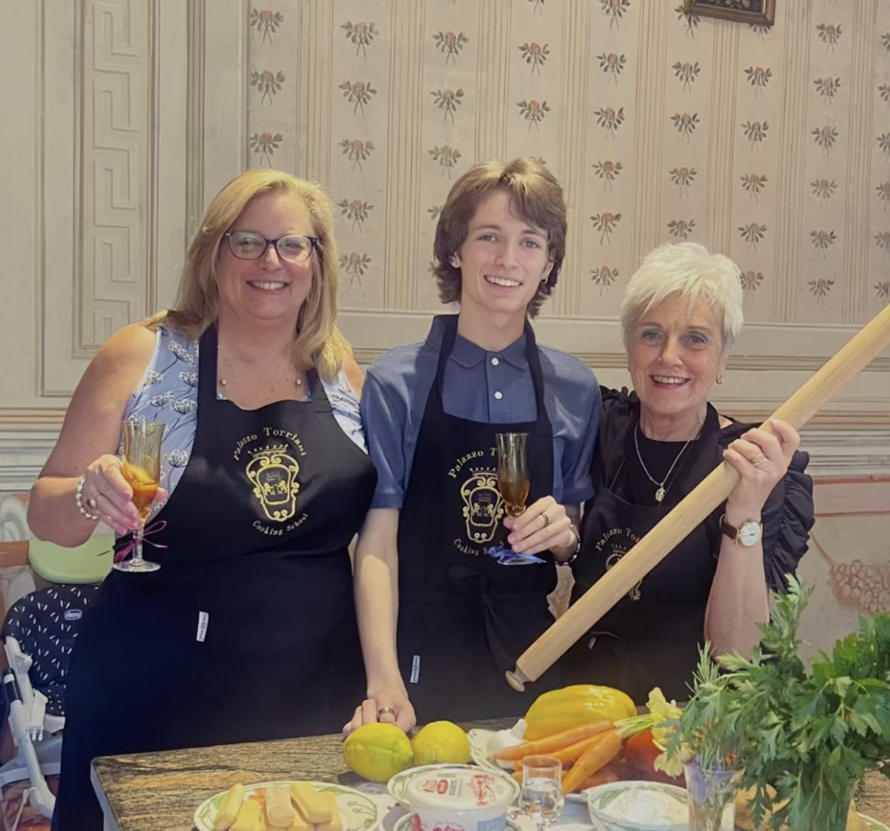 Three people posing for a picture with one wearing an apron with a skull on it