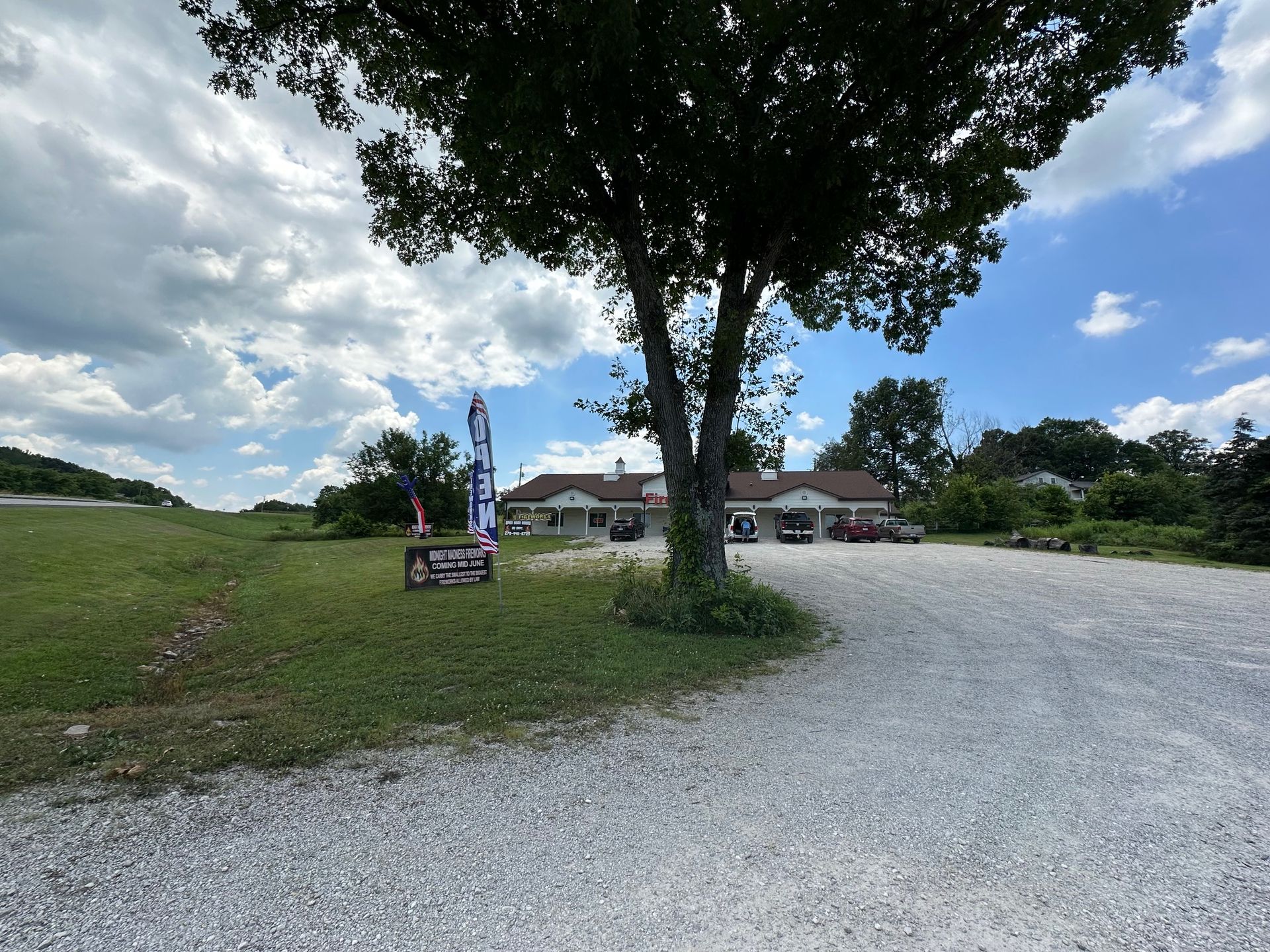 A gravel road leading to a house with a tree in the foreground