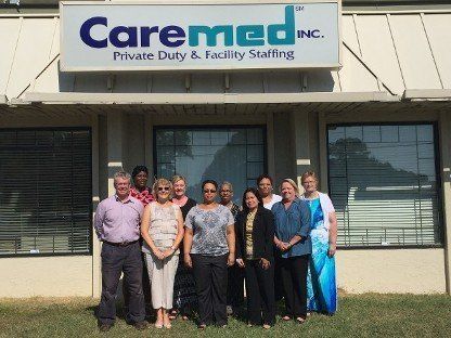 Group of staff standing outside Caremed Inc. private duty and family staffing office