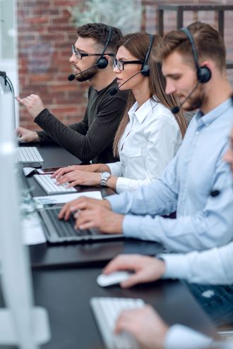a group of people wearing headsets are working on computers