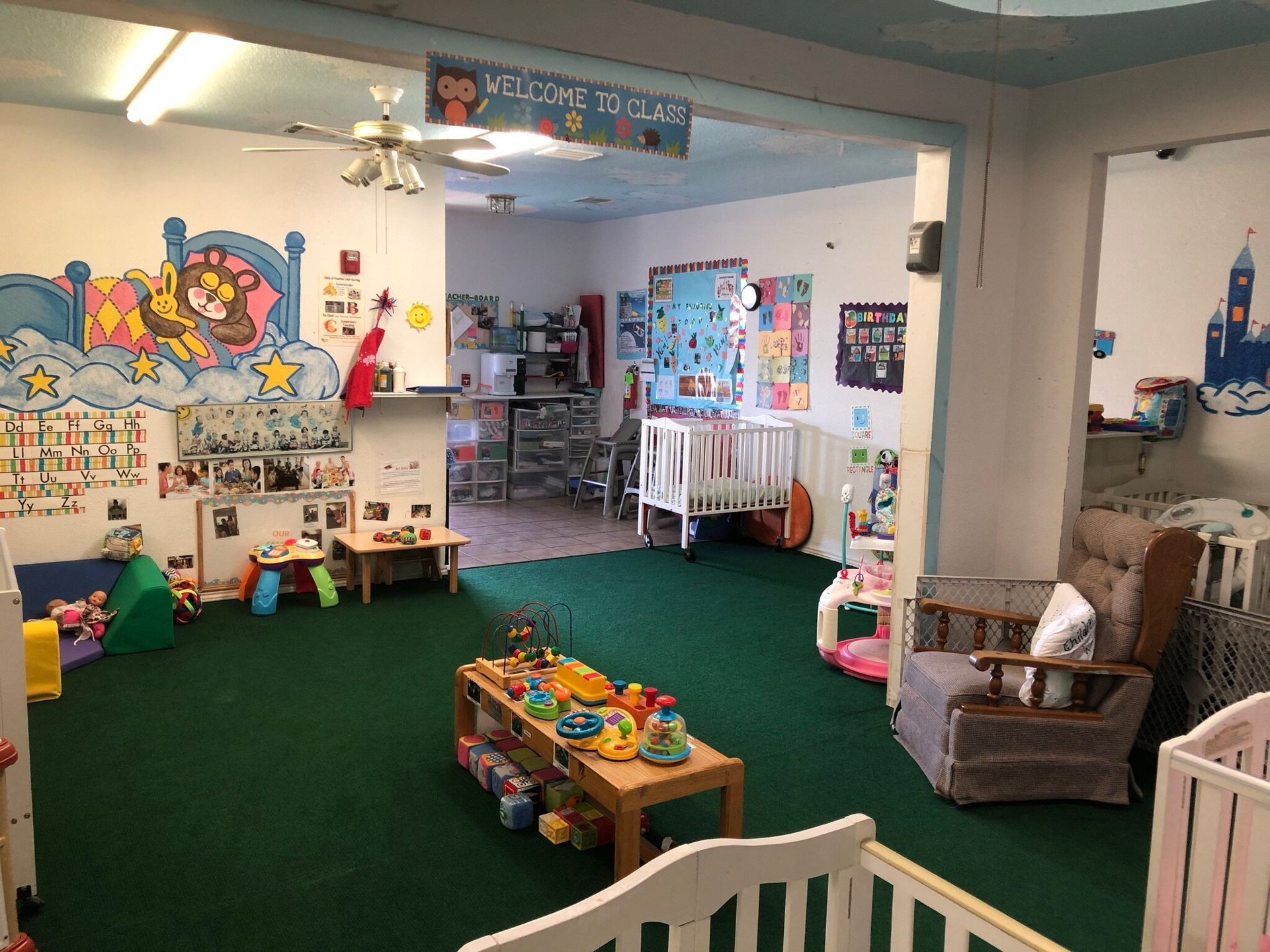 A room with a lot of toys on the floor and a ceiling fan.