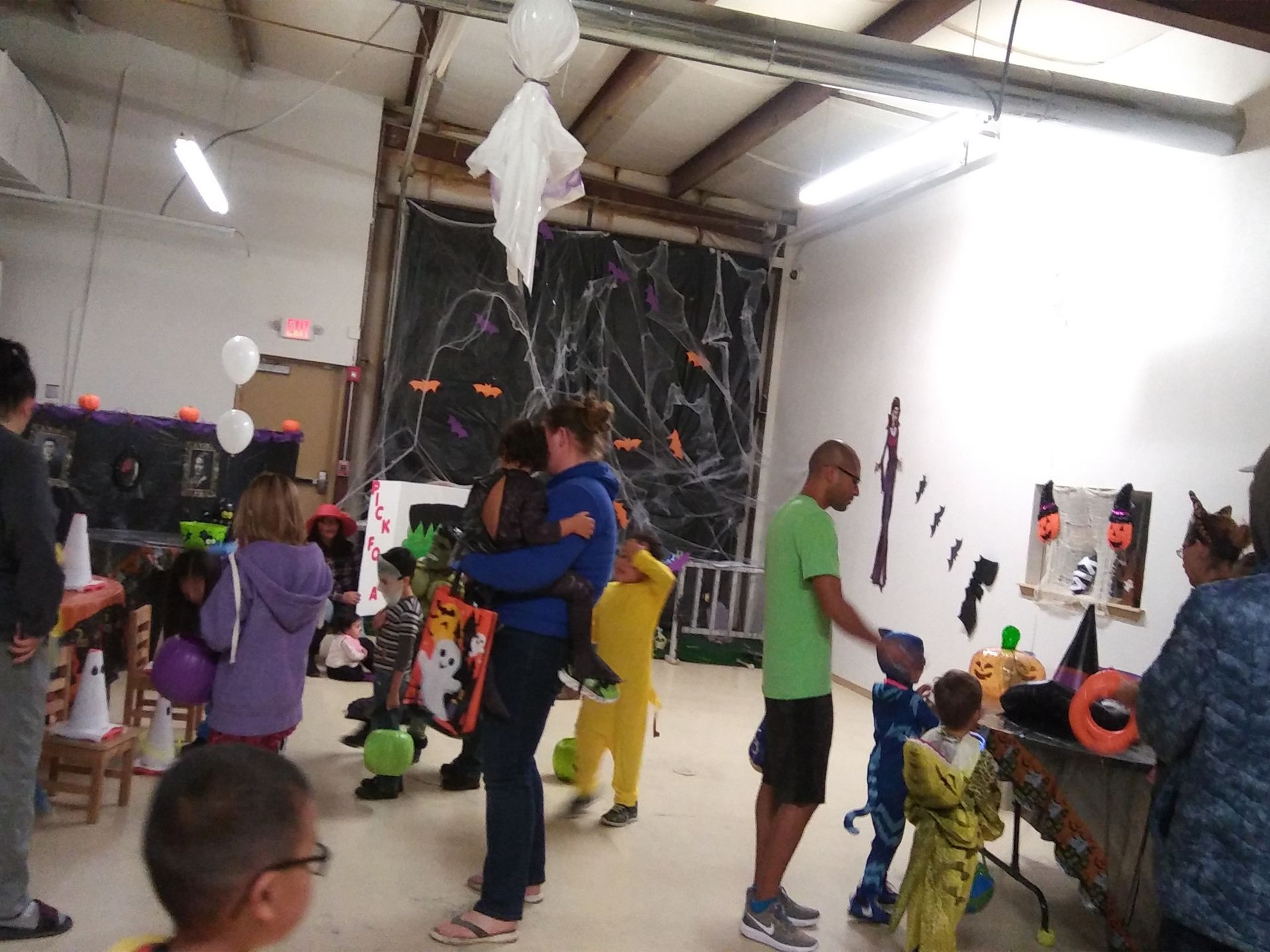 A group of people are standing in a room decorated for halloween