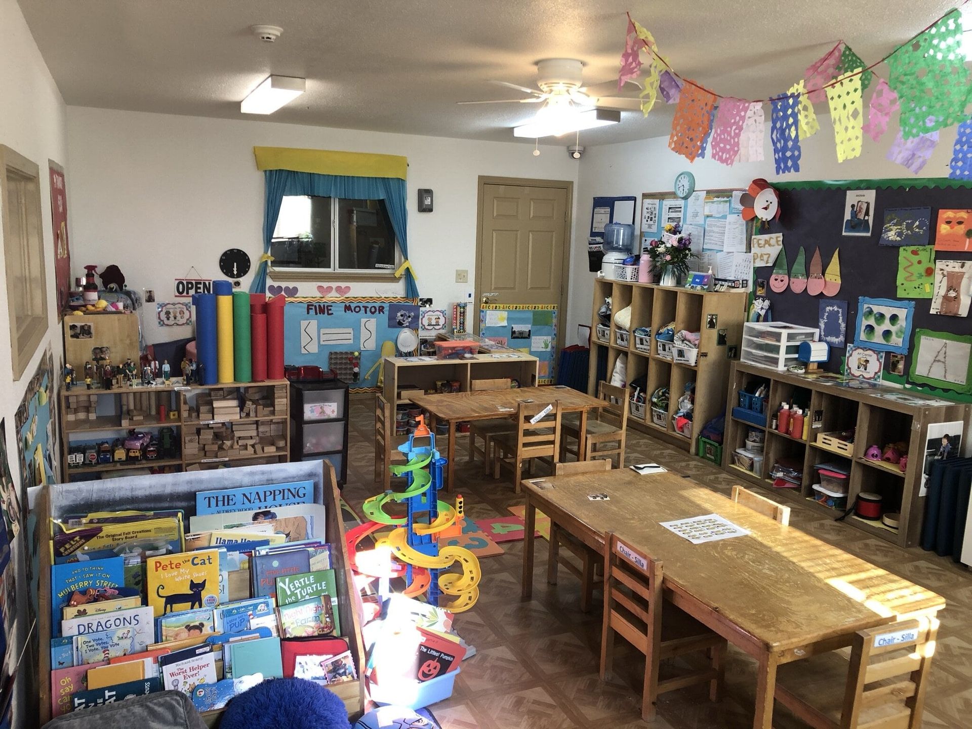 A classroom filled with tables and chairs and lots of toys.