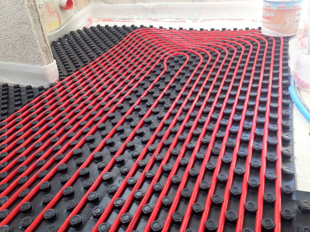 Cucina moderna con mobili bianchi, isola in legno, sgabelli neri, paraschizzi in marmo e ampia finestra.