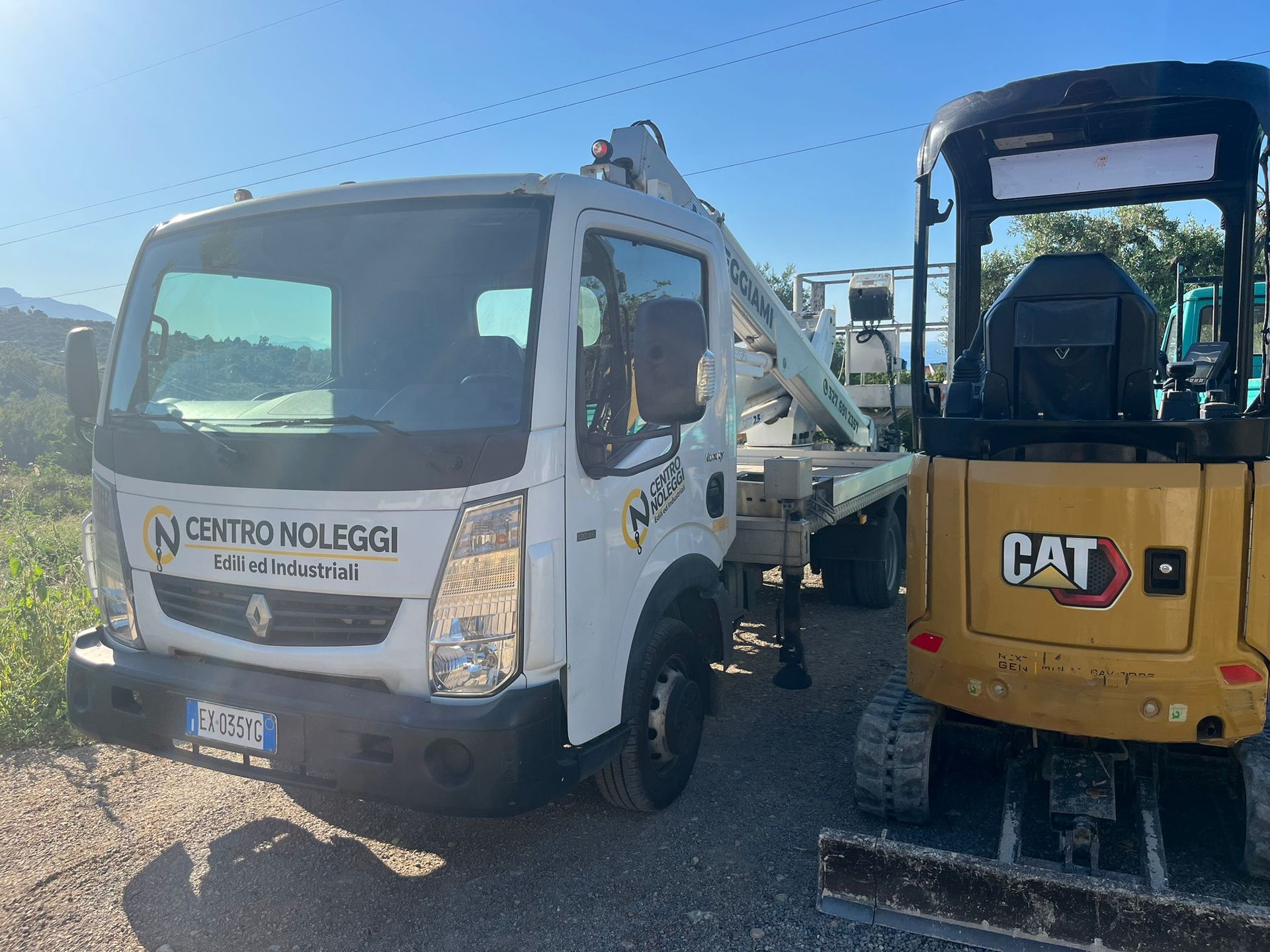 Rifacimento del manto stradale in corso; un operaio aziona un rullo BOMAG. Due uomini osservano. Asfalto in fase di stesura.