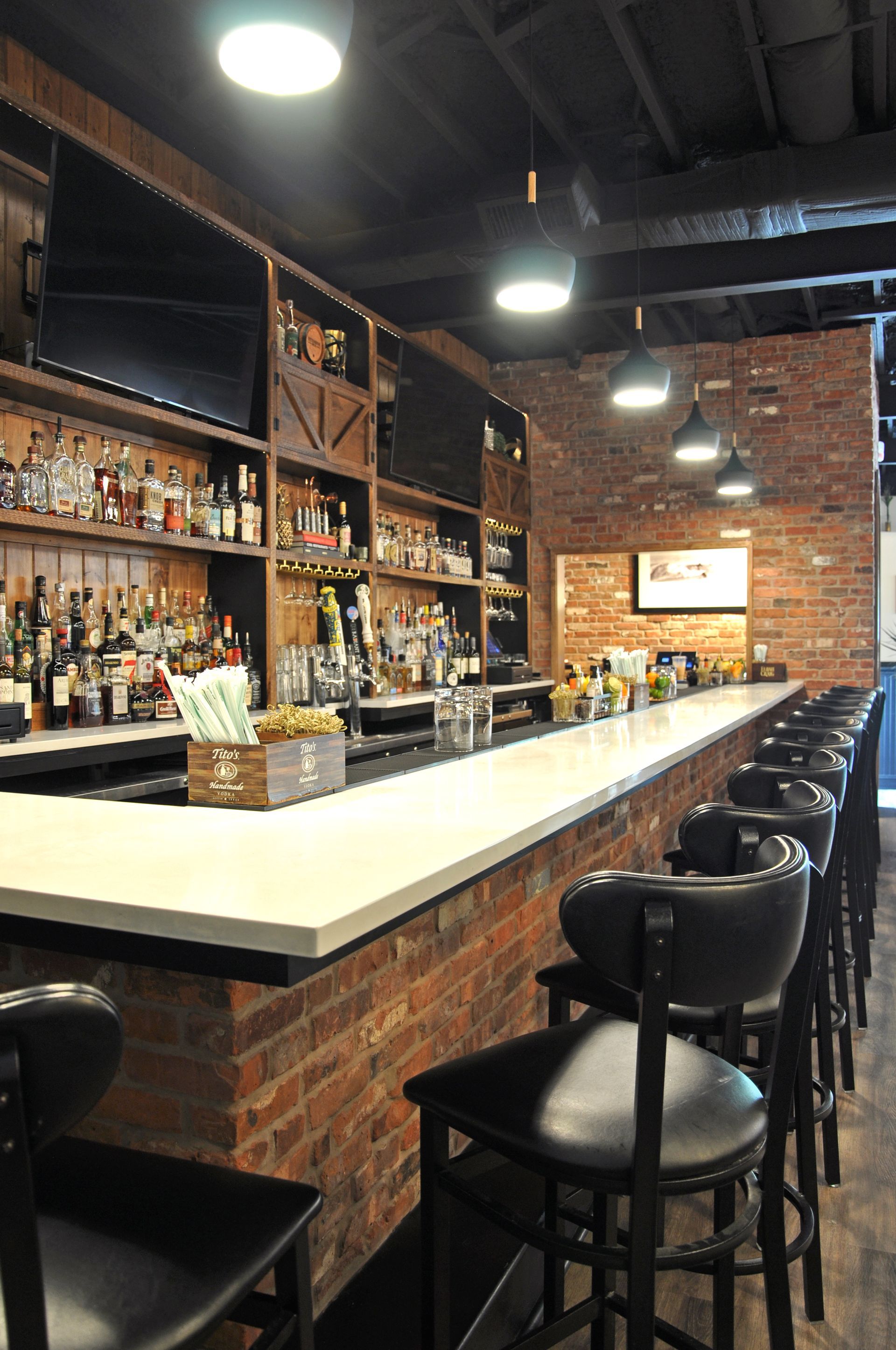 A long bar with a lot of bottles of liquor on it.