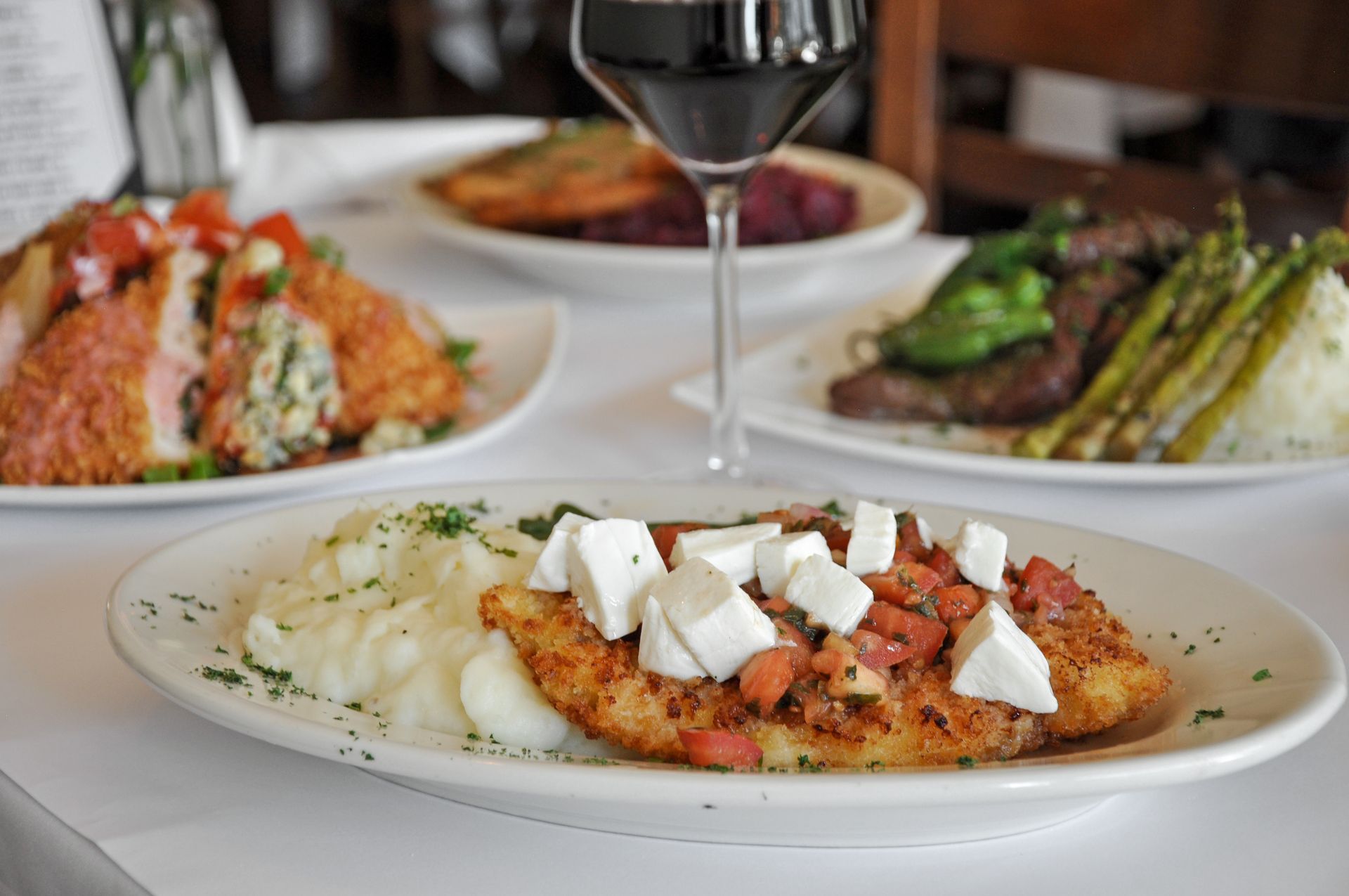 A plate of food and a glass of wine on a table.